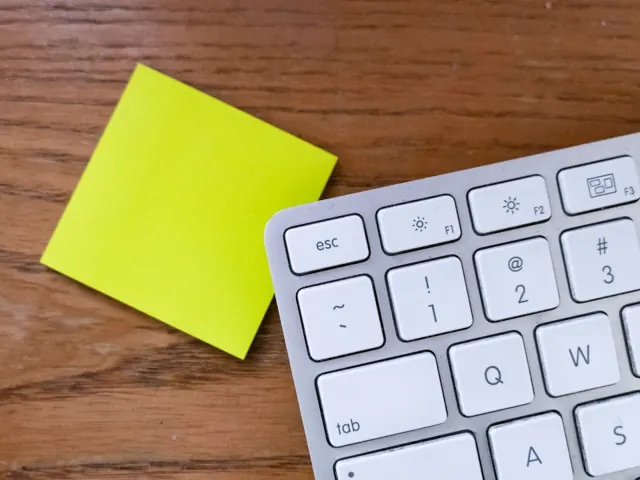 Keyboard and sticky note on a desk